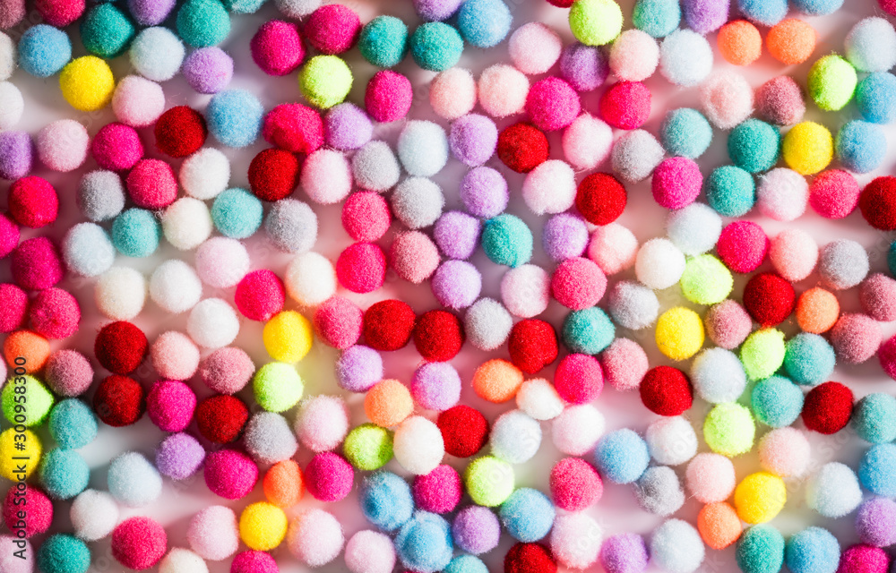 Texture of small colorful textile fluffy pompons on a white background. Flat lay. Creative. Texture of small colorful textile fluffy pompons on a white background. Flat lay. Creative.