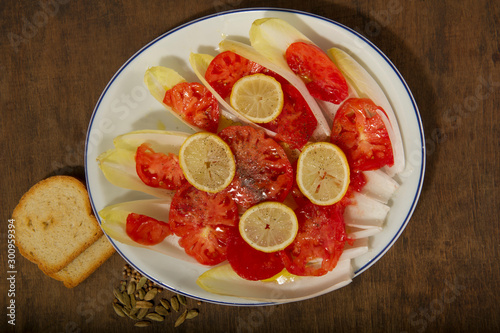 A plate of endives with tomatoes and lemons and spices