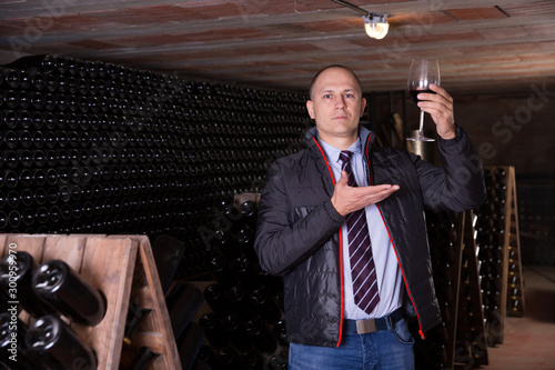 Winemaker proposing degustation of red wine photo