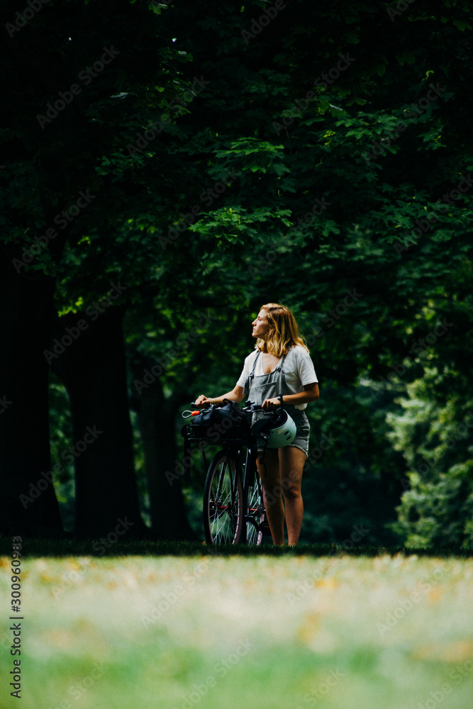 Young woman in the forest with her bike Young woman in the forest with her bike
