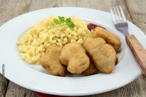 plate of chicken nuggets and coquillettes pasta