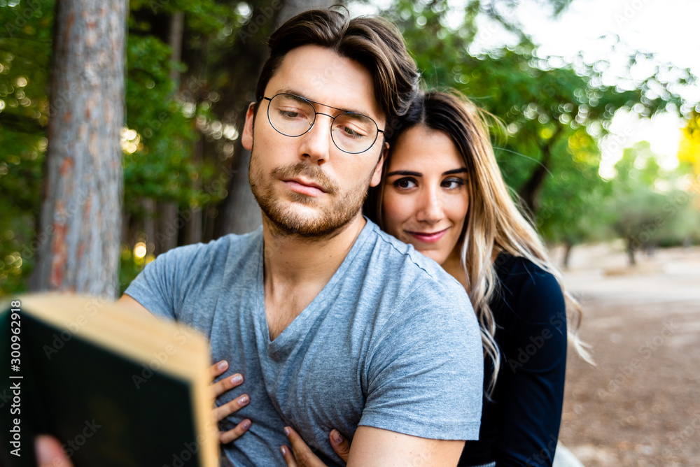 Couple in love hugging, read a book in a natural garden. Couple in love hugging, read a book in a natural garden.