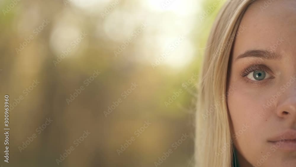Half face portrait of attractive blonde woman at the nature. Slowmotion. Half face portrait of attractive blonde woman at the nature. Slowmotion.