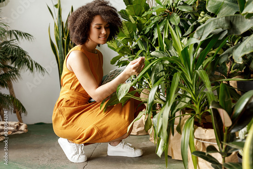 Beautiful brunette woman botanist working at her indoor garden  photo