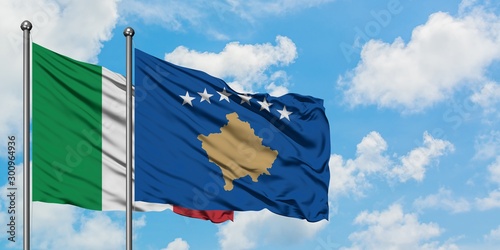 Italy and Kosovo flag waving in the wind against white cloudy blue sky together. Diplomacy concept, international relations.