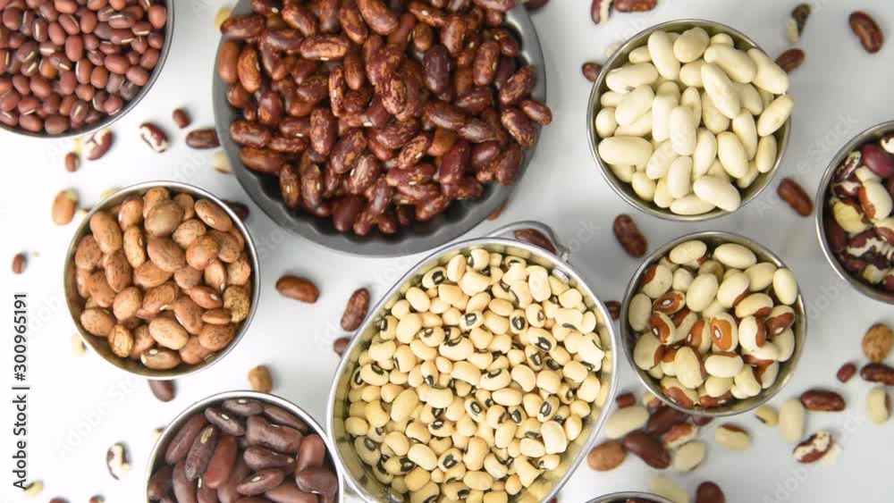 Varieties of dried beans in stainless steel containers, rotating motion