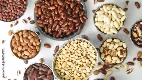 Varieties of dried beans in stainless steel containers, rotating motion