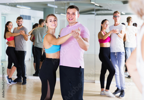 Dancing couples learning salsa at dance class