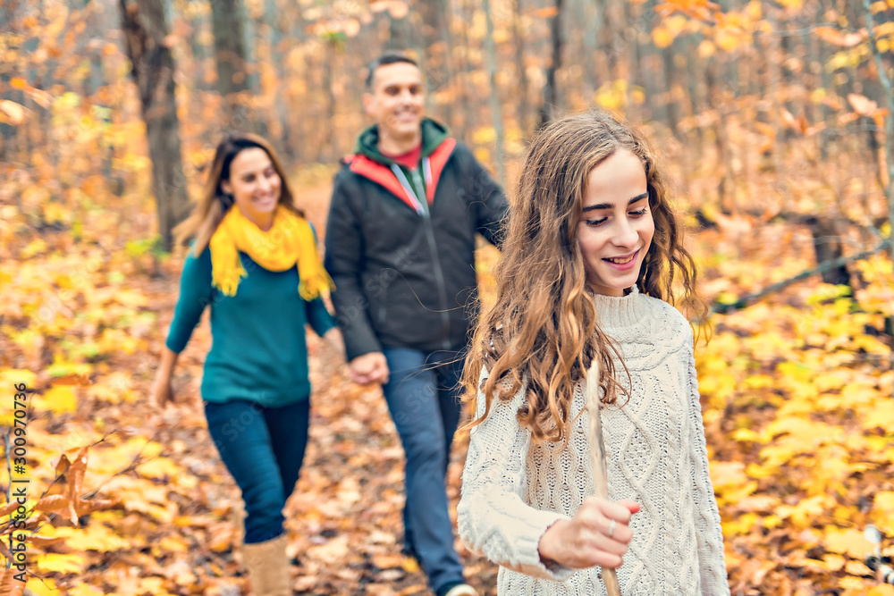 A portrait of a young family in the autumn park A portrait of a young family in the autumn park