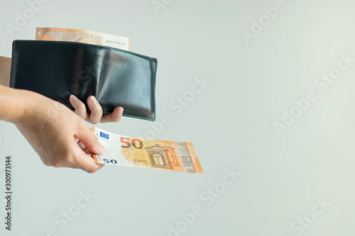 Wallpaper Mural A hand picking a banknote from the short wallet and paying in EURO currency. Torontodigital.ca