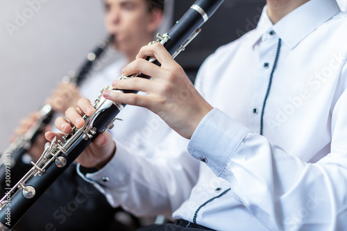 A boys with a clarinet plays music.children are engaged in music at the music school hands on a wind musical instrument close up