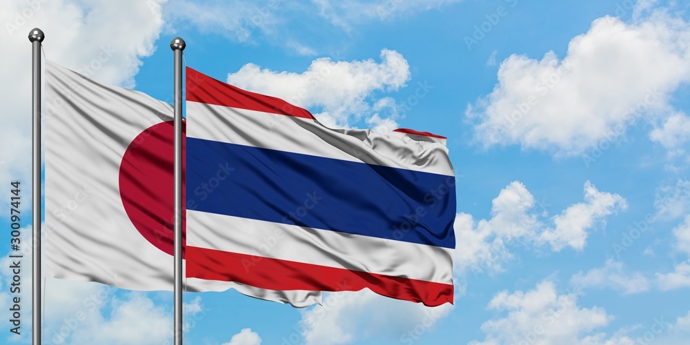Japan and Thailand flag waving in the wind against white cloudy blue sky together. Diplomacy concept, international relations.