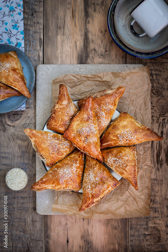 Homemade triangular pies made from ready-made puff pastry with apples