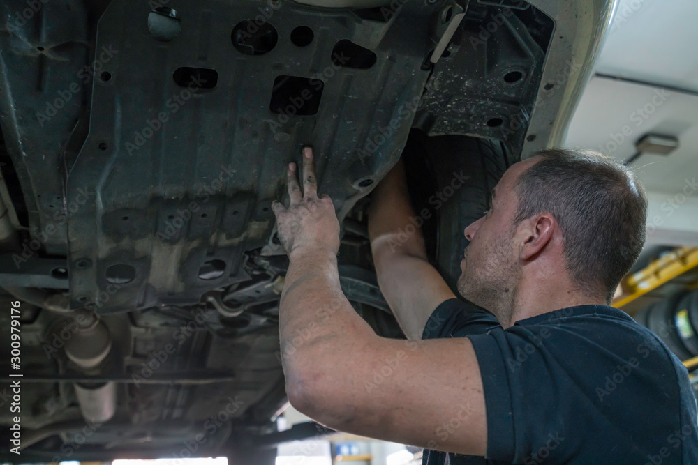 Auto mechanic working in mechanical workshop. Checking brakes and suspensions Auto mechanic working in mechanical workshop. Checking brakes and suspensions