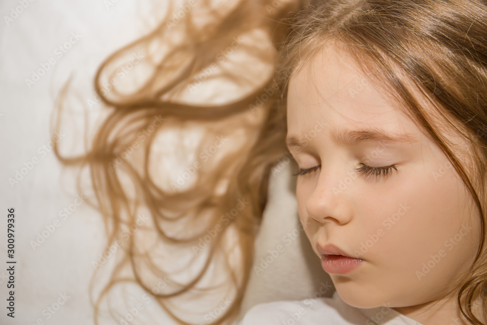 little girl with beautiful long curly hair lies in the bed little girl with beautiful long curly hair lies in the bed