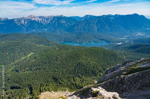 Alpine lake with mountain range and forest landscape on sunny summer day