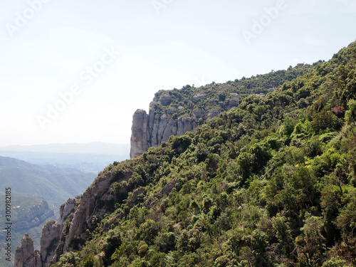 Rocky slopes of Montserrat, covered with dense vegetation.