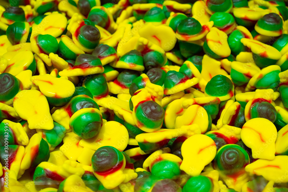 A pile of colorful marmalade candies in the form of helix yellow. green and red color. Sweet candy background A pile of colorful marmalade candies in the form of helix yellow. green and red color. Sweet candy background