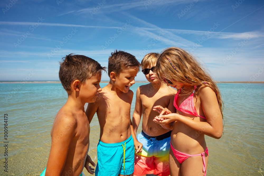Group of kids check found on beach seashell Group of kids check found on beach seashell