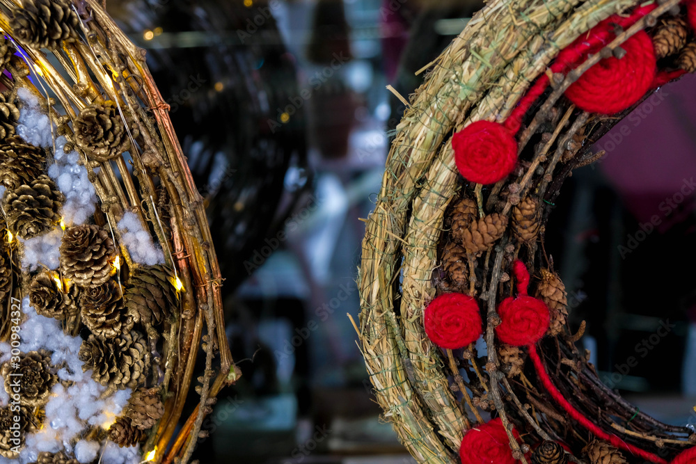 Fragment of Christmas wreaths of straw, branches, pine cones, red flowers from wool at night. Christmas in Ukraine.