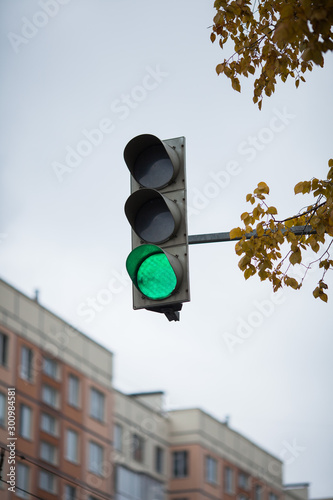 green traffic light on the sky background closeup