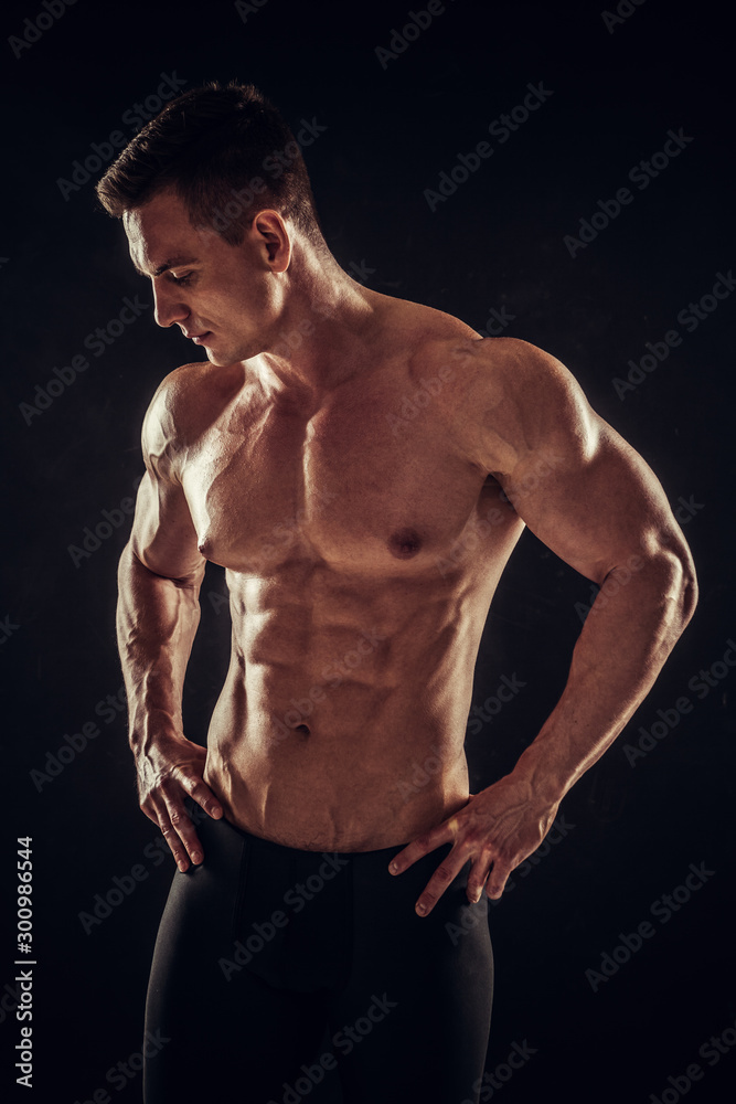 Athletic shirtless young male fitness model posing Athletic shirtless young male fitness model posing