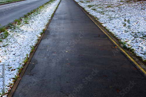First snow in park. Asphalt pavement is clean of snow. © Gints