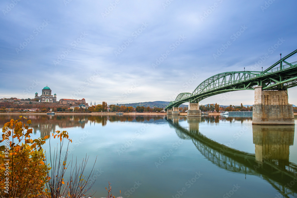Esztergom, Hungary - Autumn leaves and foliage with Maria Valeria Bridge and Basilica of the Blessed Virgin Mary at Esztergom on a morning, taken from Sturovo, Slovakia. Reflections on River Danube