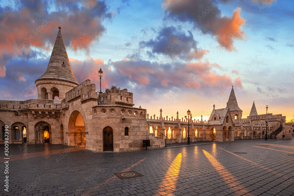 Obraz premium Budapest, Hungary - Beautiful autumn sunrise at Castle district and Fisherman's Bastion with warm sunlight and orange and blue sky and clouds