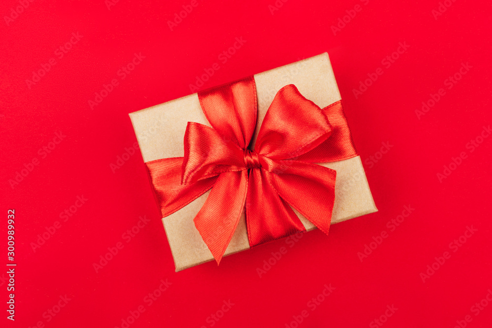 Cardboard gift box with bow on red background. Flat lay. Top view. Cardboard gift box with bow on red background. Flat lay. Top view.