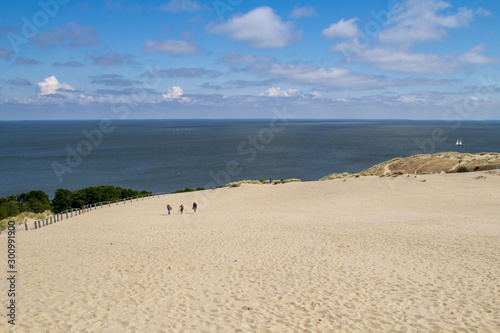 Parnidis dune in Nida. The Curonian Spit. Sand and Grass. People Walking On the Sand Dunes Images. Baltic Sea photo