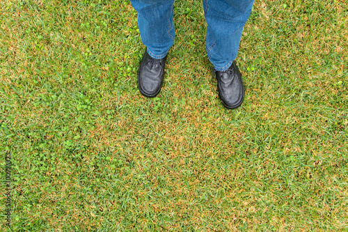 Man legs with pants and black shoes on wet sward © Formatoriginal