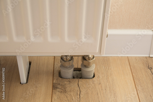 The heating battery is installed in the wooden laminate floor