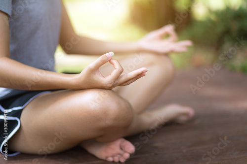 Woman practices yoga and meditates in the lotus position in peaceful place