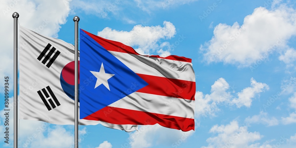 South Korea and Puerto Rico flag waving in the wind against white cloudy blue sky together. Diplomacy concept, international relations.