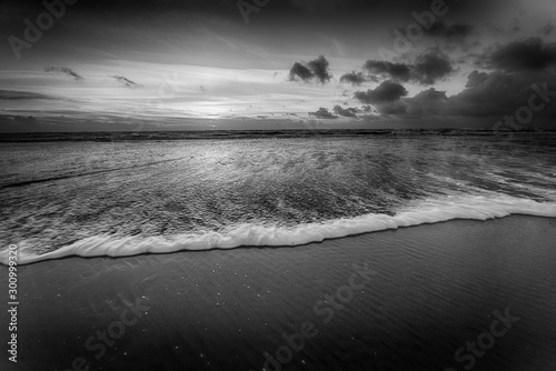 фотографія Grayscale shot of a beautiful sunset at the beach creating the perfect scenery f