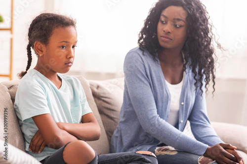 Canvastavla Disappointed black mother looking at her little daughter with reproach