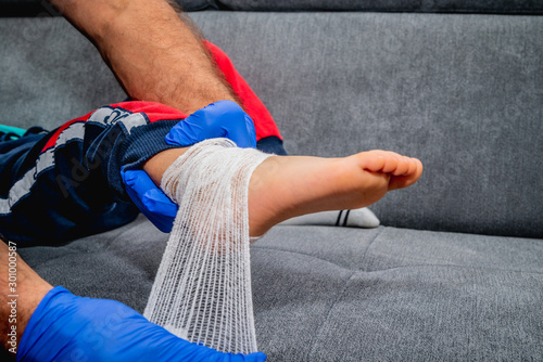 Bandaging of the child's foot. Health and pharmaceutical concept, child health problems. The doctor bandages and stiffens the child's foot, ankle. Sprain or fracture of the leg.