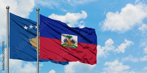 Kosovo and Haiti flag waving in the wind against white cloudy blue sky together. Diplomacy concept, international relations.