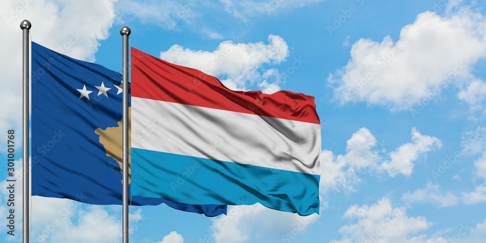 Kosovo and Luxembourg flag waving in the wind against white cloudy blue sky together. Diplomacy concept, international relations. Kosovo and Luxembourg flag waving in the wind against white cloudy blue sky together. Diplomacy concept, international relations.