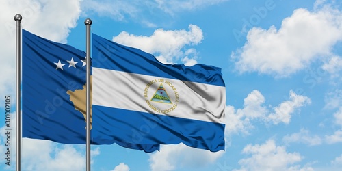 Kosovo and Nicaragua flag waving in the wind against white cloudy blue sky together. Diplomacy concept, international relations.