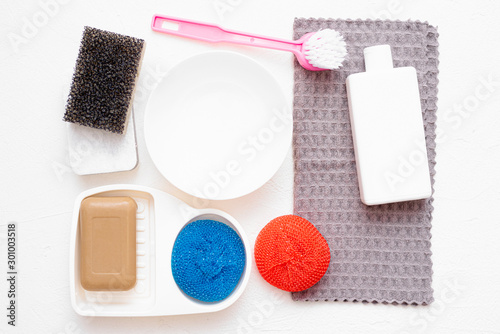 Dish washing accessories on the white flat lay background. Washing up concept.