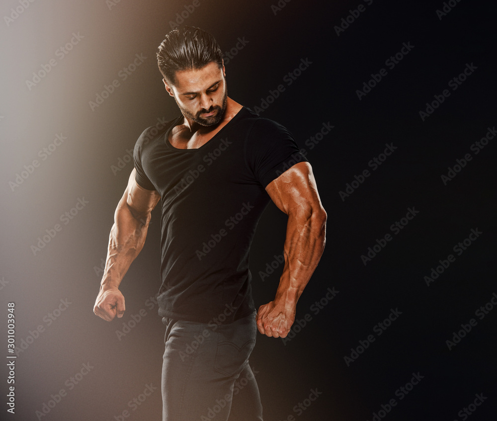 Fototapeta premium Handsome Male Fitness Model Wearing Jeans and Black T-Shirts