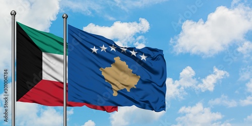 Kuwait and Kosovo flag waving in the wind against white cloudy blue sky together. Diplomacy concept, international relations.