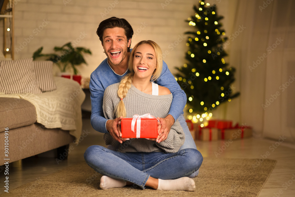 Christmas eve. Young man and woman with gift box Christmas eve. Young man and woman with gift box
