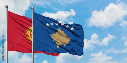 Kyrgyzstan and Kosovo flag waving in the wind against white cloudy blue sky together. Diplomacy concept, international relations.