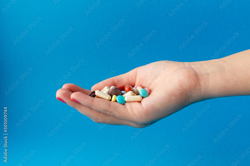 A handful of colored pills on the palm. Medical concept. Shopping at the pharmacy. A handful of colored pills on the palm. Medical concept. Shopping at the pharmacy.