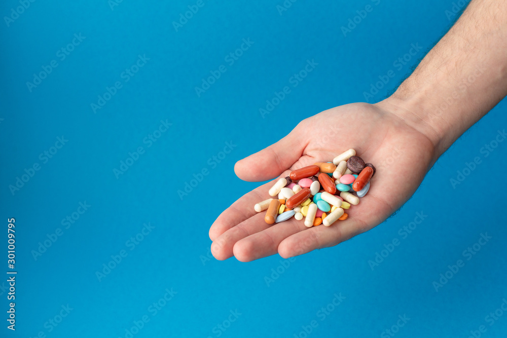 A handful of colored pills on the palm. Medical concept. Shopping at the pharmacy. A handful of colored pills on the palm. Medical concept. Shopping at the pharmacy.
