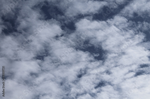 The movement of white light fluffy clouds in the blue sky.