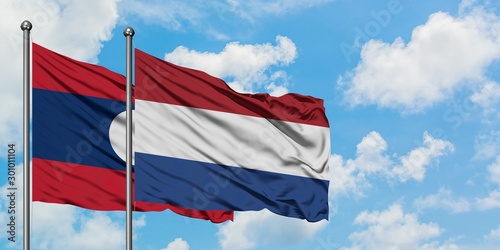 Laos and Netherlands flag waving in the wind against white cloudy blue sky together. Diplomacy concept, international relations.